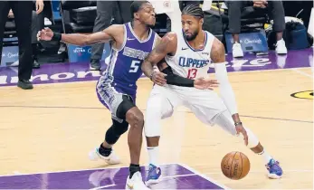  ?? RICH PEDRONCELL­I/AP ?? Clippers forward Paul George, right, drives to the basket against the Kings’ De’Aaron Fox during the first quarter Friday night.