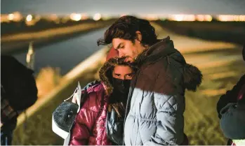  ?? GREGORY BULL/AP ?? A couple from Cuba wait to be processed to seek asylum after crossing the border Jan. 6 into the United States, near Yuma, Arizona. An undergroun­d market has emerged for migrants seeking U.S. sponsors.