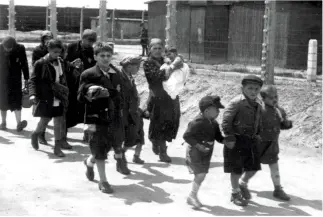  ??  ?? RIGHT: Birkenau, Poland, May 1944. Women and children on their way to gas chamber number 4