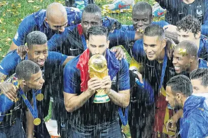  ?? PHOTO: REUTERS ?? Can’t dampen these spirits . . . France’s Adil Rami kisses the trophy as he celebrates with teammates after winning the World Cup in Russia earlier this month.