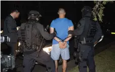  ?? EPA ?? Australian federal police officers make one of their arrests in a series of raids across Sydney early yesterday