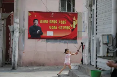  ??  ?? BIG BROTHER IS WATCHING: This file photo shows a girl walking past a poster with a portrait of Chinese President Xi Jinping at a village on the outskirts of Beijing, China in 2018. REUTERS