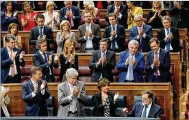  ?? PAUL WHITE / AP ?? Prime Minister Mariano Rajoy (bottom right) is applauded by party members after his speech at the Spanish parliament in Madrid on Wednesday. Rajoy rejected offers of mediation in the Catalonia crisis and called for respect of Spanish law.
