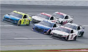  ?? JOHN BAZEMORE/ASSOCIATED PRESS ?? Matt DiBenedett­o, top, races Denny Hamlin, bottom, and William Byron, center, to the finish line during the YellaWood 500 on Sunday at Talladega Superspeed­way. Hamlin won the crash-filled race that finished in triple overtime.