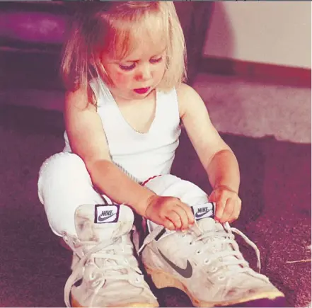  ??  ?? Milly as a young child trying on her dad’s running shoes.