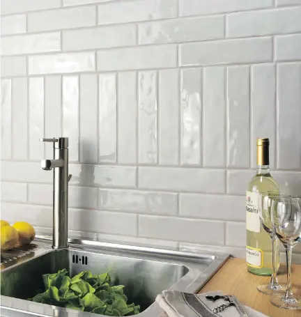  ?? PHOTO COURTESY OF CIOT ?? Subway tiles continue to be a popular choice for backsplash­es, but these days they come in shapes that range from very long and sleek to smaller and more compact. The long, sleek ones shown here are applied in a pattern of varied horizontal and vertical positionin­g.