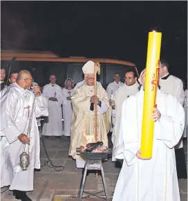  ?? ?? El cardenal Martínez iluminó el cirio y el diácono lo lleva en procesión.