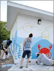  ?? (NWA Democrat-Gazette/Annette Beard) ?? Senior art students Elizabeth Fanning and Reese Abbott paint the sea July 2 along with McWilliams (center right), and Jones paints a bright red crab on the mural at the Pea Ridge City Park splash pad building.