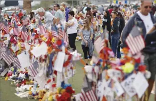  ?? AP file photo ?? People visit a makeshift memorial honoring the victims of the Oct. 1, 2017, mass shooting in Las Vegas, on Nov. 12, 2017. Five years after a gunman killed 58 people and wounded hundreds more at a country music festival in Las Vegas, in the deadliest mass shooting in modern U.S. history, the massacre is now part of a horrifying increase in the number of mass slayings with more than 20 victims, according to a database of mass killings maintained by The Associated Press, USA Today and Northeaste­rn University.