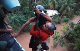  ?? — ARUN CHANDRA BOSE ?? A Naval rescue team airlifts an old woman from the terrace of her house in North Paravur district of Kerala.