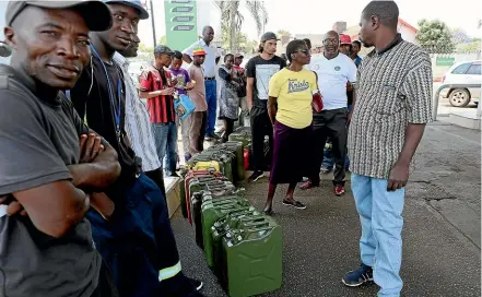  ?? AP ?? Motorists wait to fill up their containers at a fuel station in Harare. As Zimbabwe plunges into its worst economic crisis in a decade, inflation and prices are spiking and long queues are forming as shops run out of essential items.