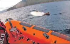  ?? Photograph courtesy Arran RNLI ?? RNLI crew attend the capsized dingy near Holy Isle.