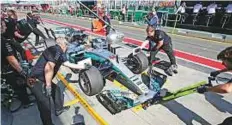  ?? AP ?? Mechanics work on Mercedes driver Lewis Hamilton’s car in the pit lane during the final practice session yesterday.