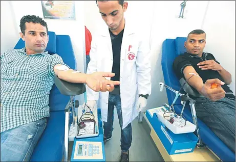  ??  ?? Libyan men donate blood during an event marking the World AIDS Day in Tripoli, on Dec 1. The World AIDS Day marks a pandemic that in 2011 claimed 1.7
million lives and led to 2.5 million new HIV infections, according to the latest UN figures. (AFP)