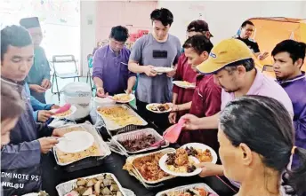  ??  ?? The homeless people enjoying the food at the gathering.