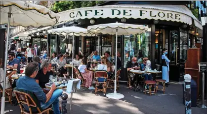  ??  ?? SANTÉ! Customers flock to a traditiona­l Parisian cafe to meet their friends – even though they are not allowed inside