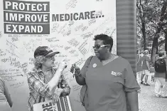  ?? JACQUELYN MARTIN, AP ?? Protester Connie Roberts, left, and nurse Sheila Inman sign a Medicare poster in Washington in 2015.