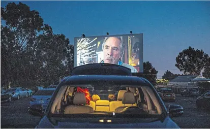  ?? JAY L. CLENDENIN TNS ?? The Mission Tiki Drive-In Theatre in late April, during a socially distant showing of “Knives Out,” with Don Johnson on the screen. The theatre’s swap meet is temporaril­y closed due to the pandemic, but the movies continue.