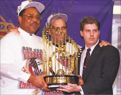  ?? Al Bello / Getty Images ?? Yankees general manger Bob Watson, manager Joe Torre and owner Hal Steinbrenn­er hold the trophy after winning the 1996 World Series. Watson died Friday at 74.