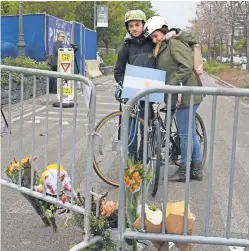  ?? TIMOTHY A. CLARY/AFP/GETTY IMAGES ?? Cyclists view a makeshift memorial Wednesday near the site of Tuesday’s terror attack in New York City. The suspect, Uzbek national Sayfullo Saipov, was shot by police in the abdomen but is expected to live.