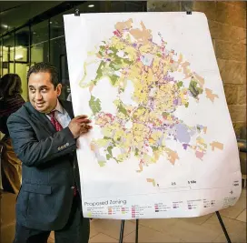  ?? PHOTOS BY JAY JANNER / AMERICAN-STATESMAN ?? Jorge Rousselin, developmen­t services manager with the city of Austin Planning and Zoning Department, shows the new proposed zoning map after the second draft of CodeNext was released at City Hall on Friday.