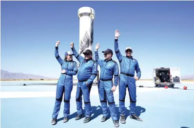  ?? The Associated Press ?? ■ Blue Origin’s New Shepard rocket’s latest space passengers, from left, Audrey Powers, William Shatner, Chris Boshuizen and Glen de Vries raise their hands during a media event at the spaceport near Van Horn, Texas, on Wednesday.