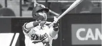  ?? Ronald Martinez, Getty Images ?? L. A.’ s Cody Bellinger hits a solo home run that propelled the Dodgers to a Game 7 win.