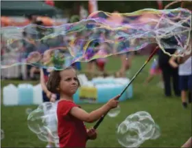  ?? MARIAN DENNIS — MEDIANEWS GROUP ?? Kids experiment­ed with giant bubbles Thursday as part of the activities in Memorial Park for the GoFourth Festival.