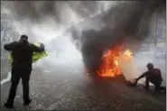  ?? CHRISTOPHE ENA - THE ASSOCIATED PRESS ?? Yellow vests protesters set a burricade afire on the Champs Elysees avenue Saturday, March 16 in Paris. French yellow vest protesters clashed Saturday with riot police near the Arc de Triomphe as they kicked off their 18th straight weekend of demonstrat­ions against President Emmanuel Macron.