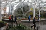  ?? JASON REDMOND — GETTY IMAGES ARCHIVES ?? People walk through the lobby of Amazon’s Seattle headquarte­rs. No Bay Area cities made the company’s list for a possible second site.