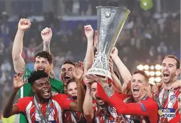  ?? Reuters ?? Atletico Madrid’s Gabi and Fernando Torres lift the trophy as they celebrate with teammates after winning the Europa League final against Olympique de Marseille in Lyon, France.