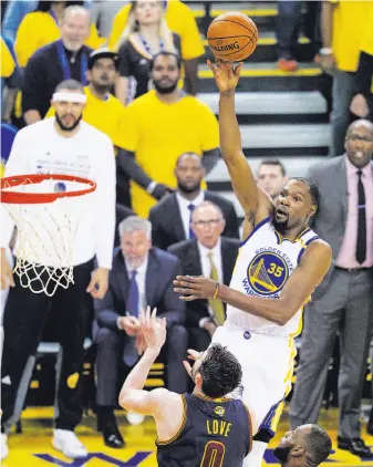  ?? Carlos Avila Gonzalez / The Chronicle ?? Kevin Durant shoots over Cleveland’s Kevin Love. Durant finished with 38 points and was particular­ly effective in the first half: 23 points, six assists and four rebounds.