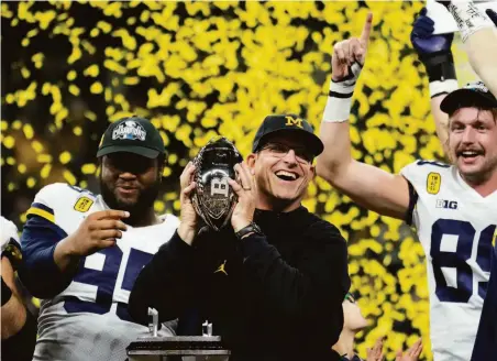  ?? AJ Mast / Associated Press ?? Michigan head coach Jim Harbaugh celebrates with his team after they won the Big Ten championsh­ip in Indianapol­is.