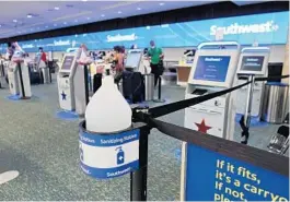  ?? PHOTOS BY KEVIN SPEAR/ORLANDO SENTINEL ?? Orlando Internatio­nal Airport has rebounded slowly from the pandemic as the airport and airlines ramp up their responses to COVID-19. A large jug of hand sanitizer is stationed at Southwest Airlines’ ticket counters.