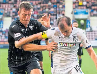  ?? Picture: SNS. ?? Lee Ashcroft goes up against Dundee’s Paul Mcgowan.