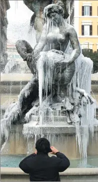  ?? MAX ROSSI / REUTERS ?? A man takes pictures in front of the frozen Naiadi fountain in downtown Rome on Wednesday.