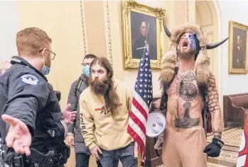  ?? MANUEL BALCE CENETA/AP ?? Jacob Chanlsey, right, and other supporters of then-President Trump are confronted by U.S. Capitol Police during the Jan. 6 riot in Washington. Chansley has since written an apology to a judge from jail, asking for patience.