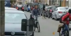  ?? FOTO RR ?? Enkele scholieren fietsen voorbij, op de achtergron­d neemt Righard d.R. de fiets van een leerling mee.