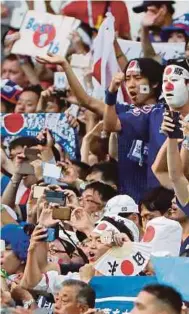  ?? REUTERS PIC ?? Japan fans celebrate after they qualified for the next round despite losing 1-0 to Poland on Thursday.