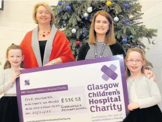  ??  ?? Quids in Emma and Emily McHugh handed their presents and a cheque to Lara McDonald of the Glasgow Children’s Hospital Charity alongside Greenhills Primary head teacher Elaine Johnston