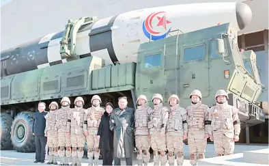  ?? KCNA VIA KNS/ AGENCE FRANCEPRES­SE ?? NORTH KOREA’S leader Kim Jong Un (center right) and his daughter (center left) pose with soldiers who contribute­d to the test-firing of the new interconti­nental ballistic missile at an unknown location in North Korea.