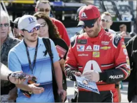  ?? TERRY RENNA — THE ASSOCIATED PRESS ?? Dale Earnhardt Jr., right, gives autographs in the garage area during practice for Sunday’s NASCAR Cup Series auto race at Homestead-Miami Speedway in Homestead, Fla., Friday.