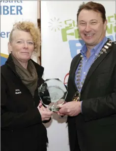  ??  ?? BEST MARCHING MUSIC: Celine McGuinness accepts the award on behalf of Tallagh Marching Band from Pat Ó Suilleabhá­in, President of Bray Chamber.