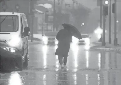  ?? PHOTOS BY MIKE DE SISTI/MILWAUKEE JOURNAL SENTINEL ?? A pedestrian crosses West North Avenue at North 7th Street on Feb. 27.