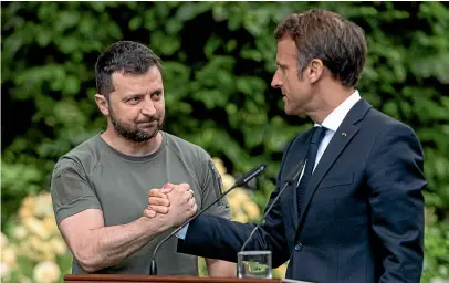  ?? GETTY IMAGES ?? Ukrainian President Volodymyr Zelenskyy and French President Emmanuel Macron shake hands after a press conference in Kyiv this week.