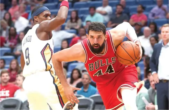  ?? | AP ?? Bulls forward Nikola Mirotic drives past former teammate Rajon Rondo during the first half of a preseason game Tuesday against the Pelicans. Mirotic scored 14 points.