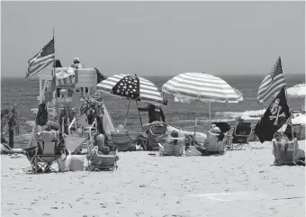  ?? [WAYNE PARRY/ THE ASSOCIATED PRESS] ?? Flags line the beach in Belmar, N.J., on June 28. With large crowds expected at the Jersey Shore for the July Fourth weekend, some are worried that a failure to heed mask-wearing and social distancing protocols could accelerate the spread of the coronaviru­s.