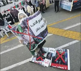  ?? Mahmud Turkia AFP/Getty Images ?? A WOMAN holds an anti-Khalifa Haftar sign during a Tripoli gathering Friday to mark Libya’s 70th anniversar­y of independen­ce from Britain and France.