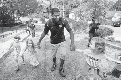  ?? ALGERINA PERNA/BALTIMORE SUN ?? Coppin State University basketball player Keith Shivers runs around the block on Wednesday with, from left, Fiona D’Andrea, Olivia Cromin and Poppy McDonald, all pupils at Mount Washington Elementary/Middle School. The Coppin men’s basketball team and...