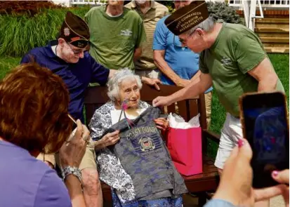  ?? JOHN TLUMACKI/GLOBE STAFF ?? WWII Coast Guard veteran, Yolanda Cerullo (center), was presented with a Coast Guard Tshirt by Vietnam veteran Ed Powers (right) at her 100th birthday celebratio­n, on Saturday.